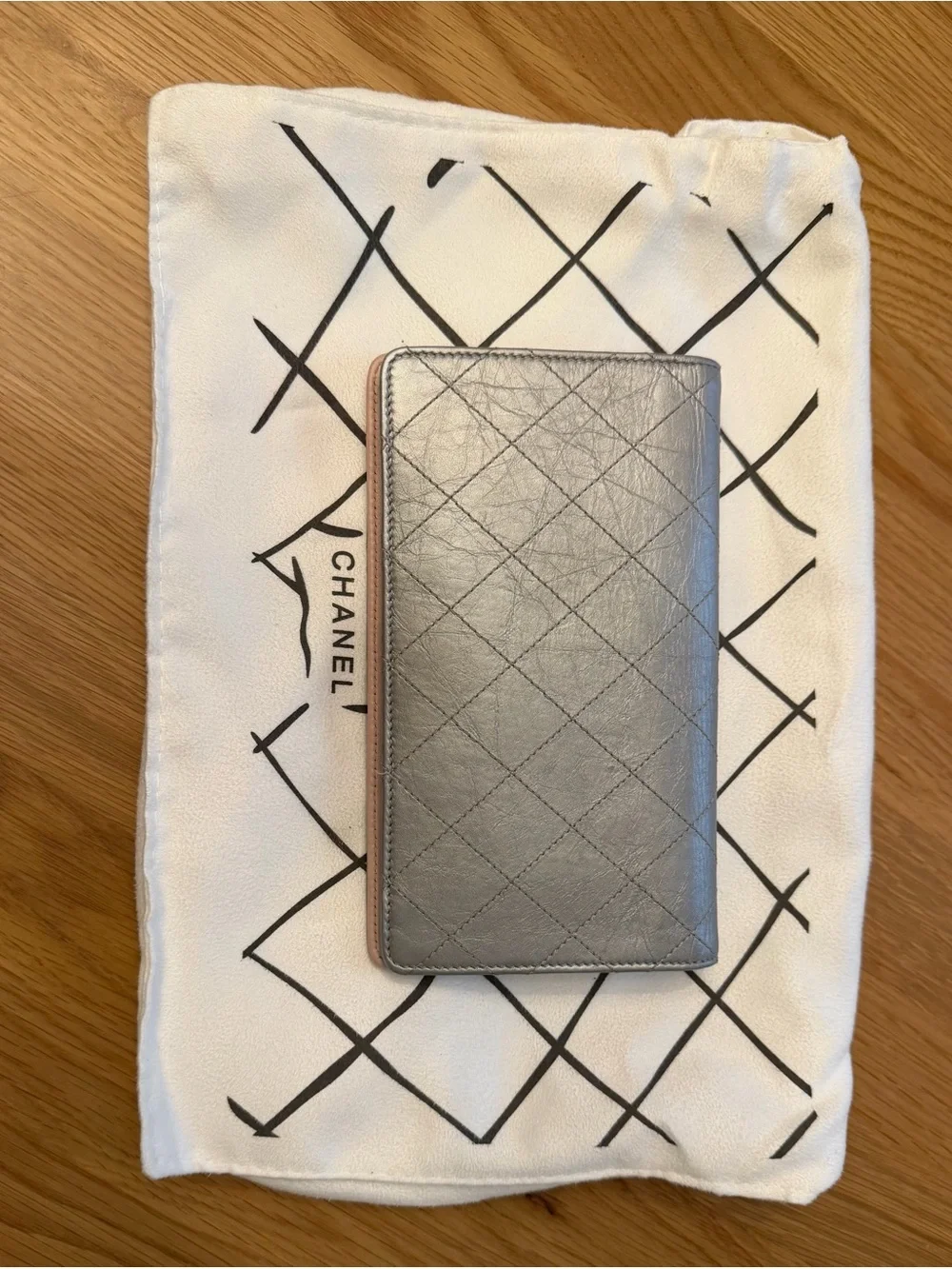 Authentic Chanel Silver Lambskin Leather with Gunmetal/Crystal CC